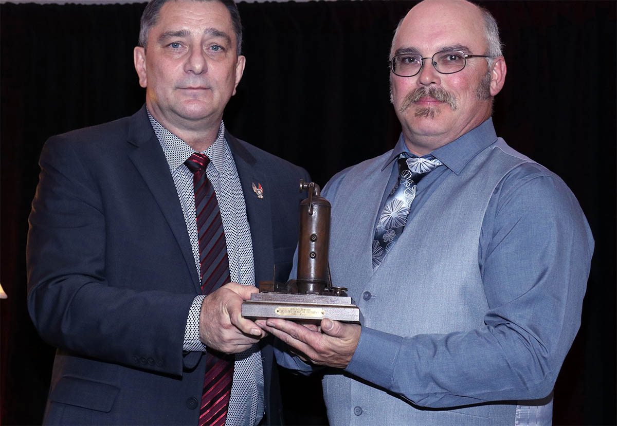 International Vice-President Arnie Stadnick presents Chris Kiwior with the Industry Award of Excellence which he accepted on behalf of his father Joe Kiwior.
